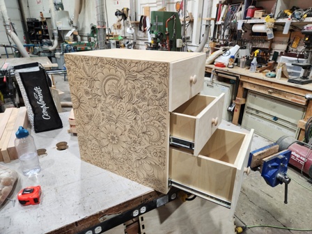 A three-drawer cabinet with a laser etched design.